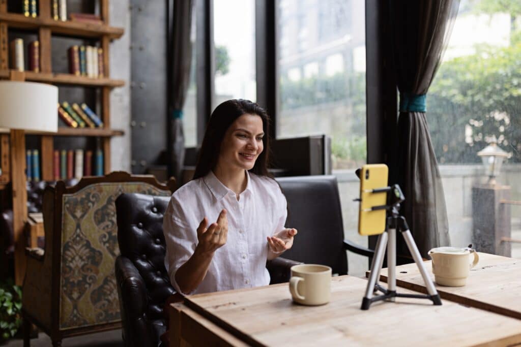 Happy Young Caucasian Influencer Using Mobile Phone in Cafe